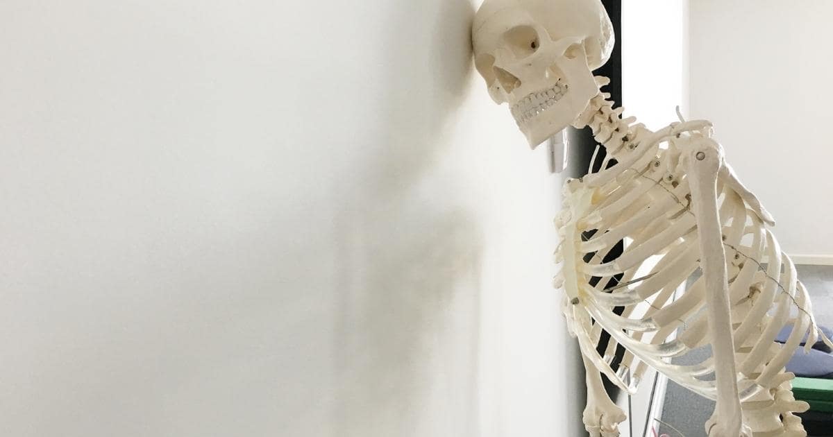skeleton leaning against wall