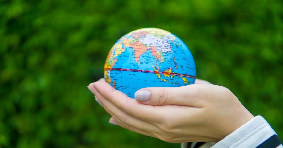 hand holding a small globe