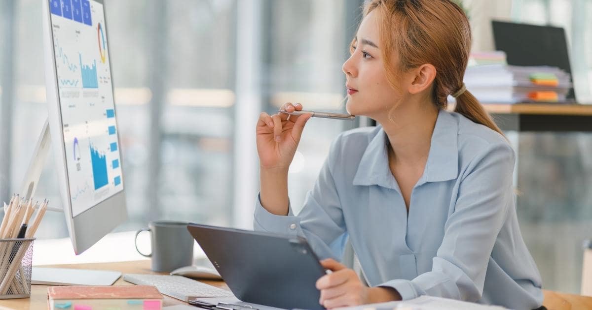 woman looking at computer screen with charts and graphs